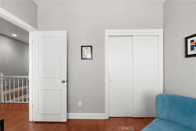 bedroom featuring a closet, wood finished floors, and baseboards