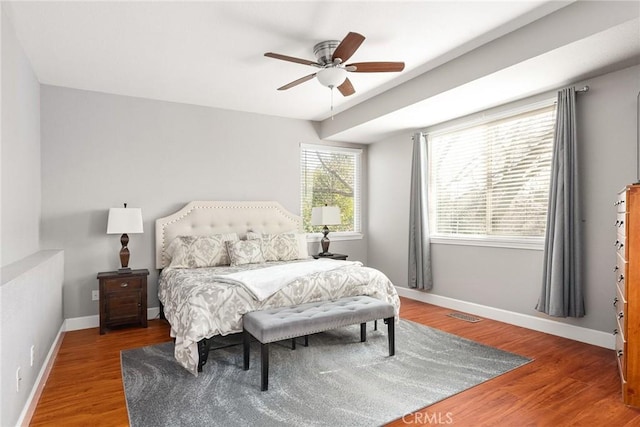 bedroom featuring a ceiling fan, baseboards, and wood finished floors