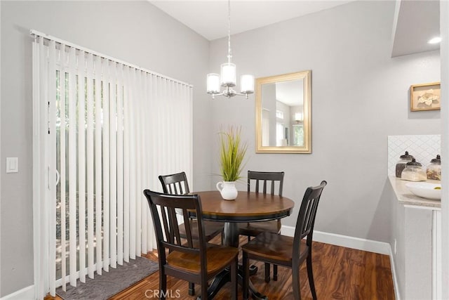 dining area with baseboards, dark wood finished floors, and a chandelier