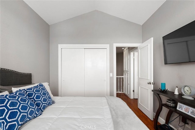 bedroom with lofted ceiling, a closet, and wood finished floors