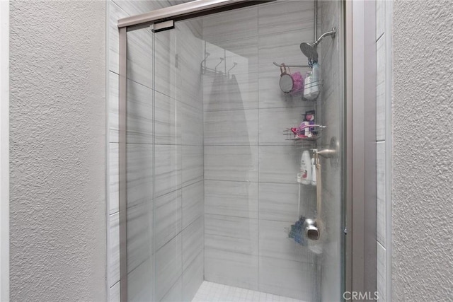 bathroom featuring a stall shower and a textured wall