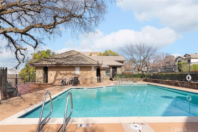 community pool featuring a patio area and fence