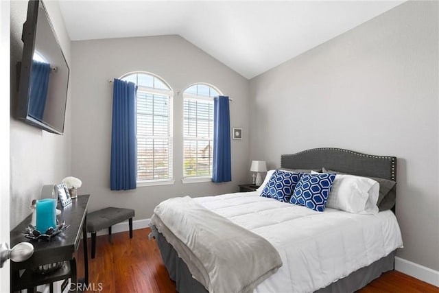 bedroom with vaulted ceiling, baseboards, and wood finished floors