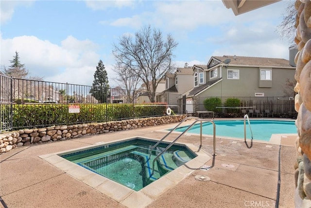 community pool featuring fence, a hot tub, and a patio