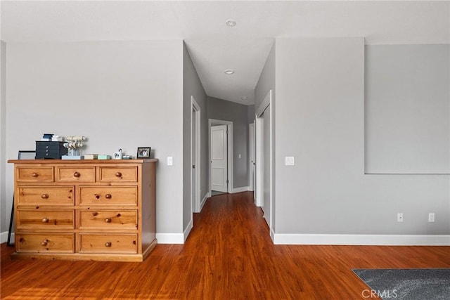 hall featuring baseboards and wood finished floors