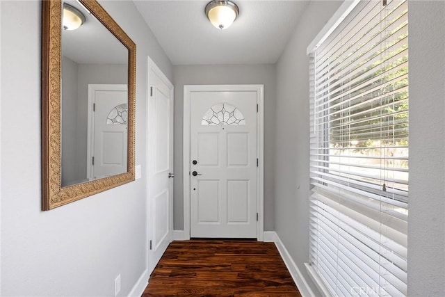 doorway with dark wood-style floors and baseboards