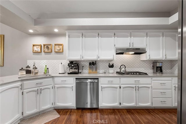 kitchen featuring white cabinets, dark wood-type flooring, stainless steel appliances, under cabinet range hood, and a sink