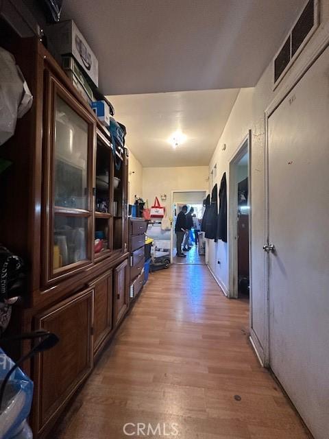 hallway featuring light wood-type flooring and visible vents