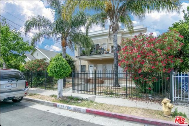 obstructed view of property with a fenced front yard and a balcony