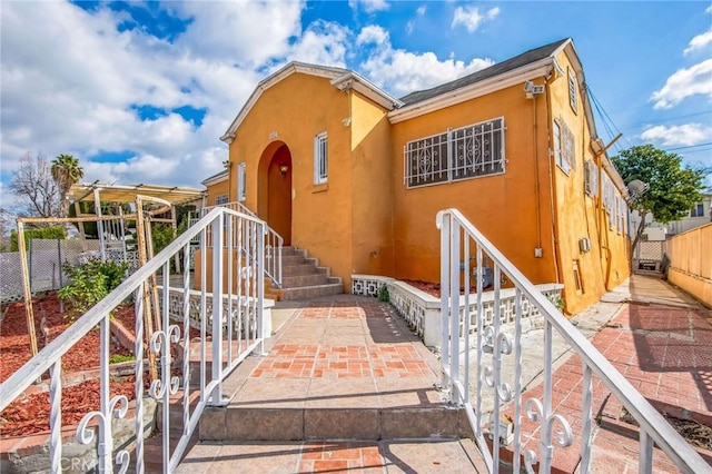 view of front of home featuring fence and stucco siding