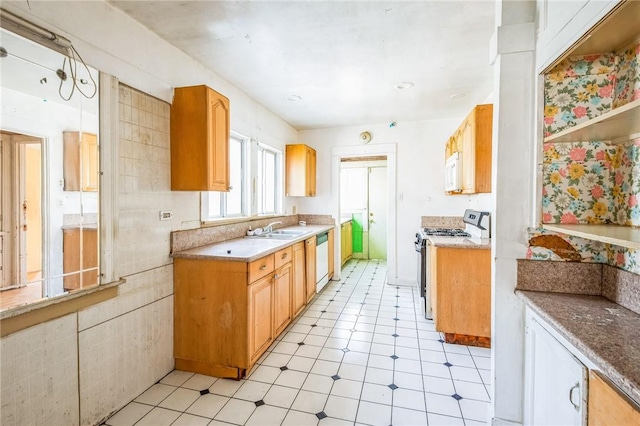 kitchen featuring light countertops, white appliances, light floors, and a sink