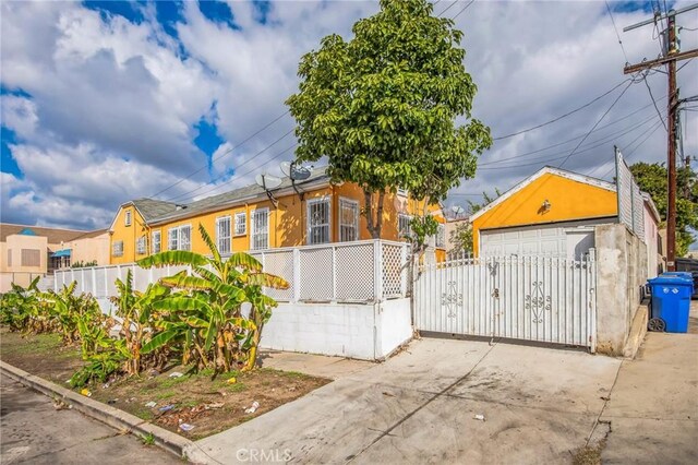 1194 S Lucerne Blvd, Los Angeles, CA 90019 - view of front of house featuring a fenced front yard, a detached garage, and a gate