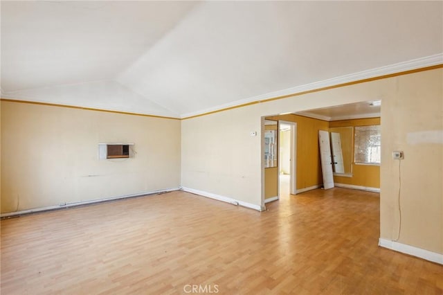 unfurnished room with lofted ceiling, light wood-type flooring, baseboards, and crown molding