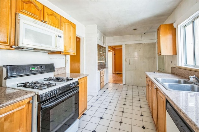 kitchen with dishwashing machine, white microwave, a sink, range with gas stovetop, and brown cabinets