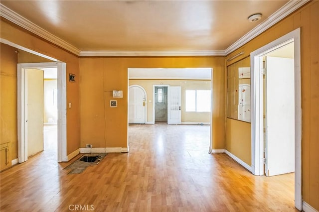 interior space featuring light wood finished floors, baseboards, and crown molding