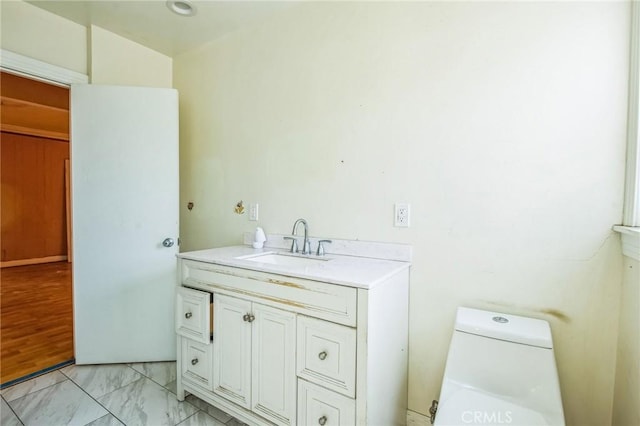 bathroom with marble finish floor, vanity, and toilet