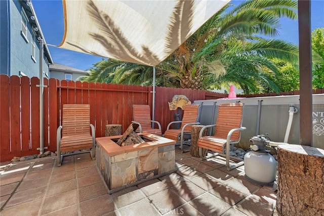 view of patio with fence and a fire pit