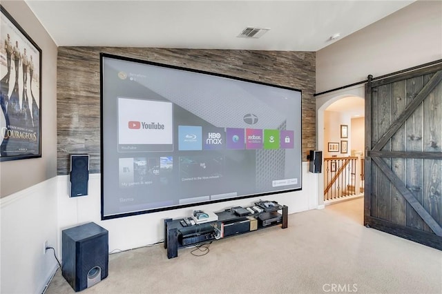 cinema featuring lofted ceiling, a barn door, carpet flooring, and visible vents