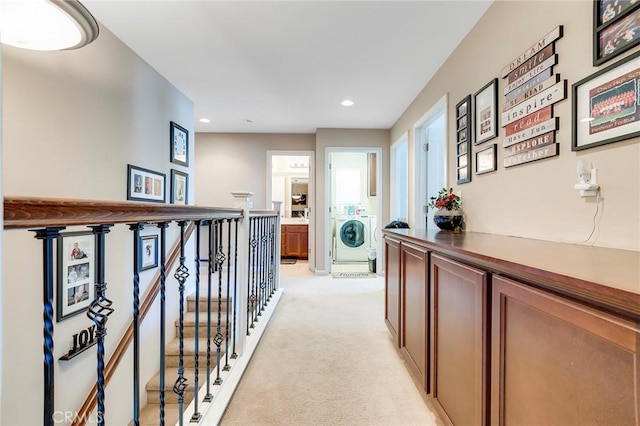 corridor featuring recessed lighting, washer / clothes dryer, light carpet, and an upstairs landing