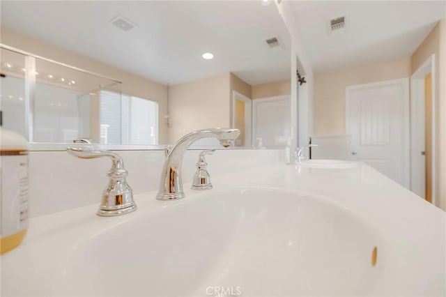 interior details featuring double vanity, a sink, and visible vents