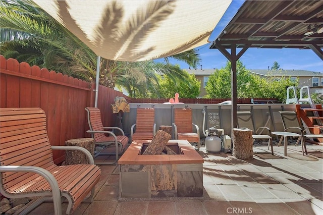 view of patio with fence and a fire pit