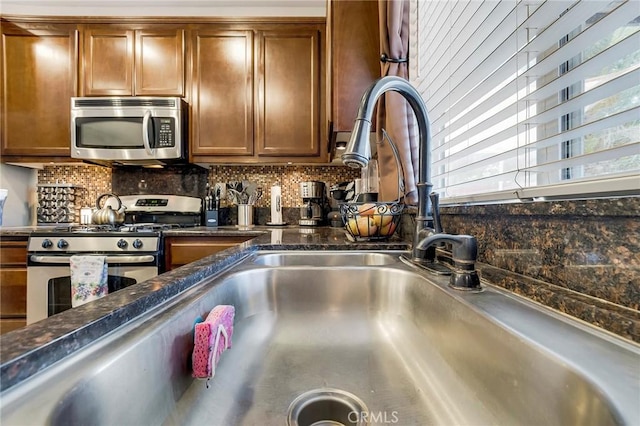 interior details featuring brown cabinets, appliances with stainless steel finishes, decorative backsplash, and dark stone countertops