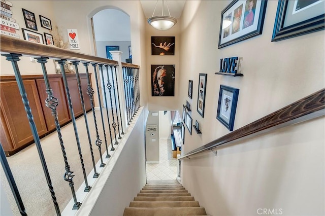 staircase featuring arched walkways