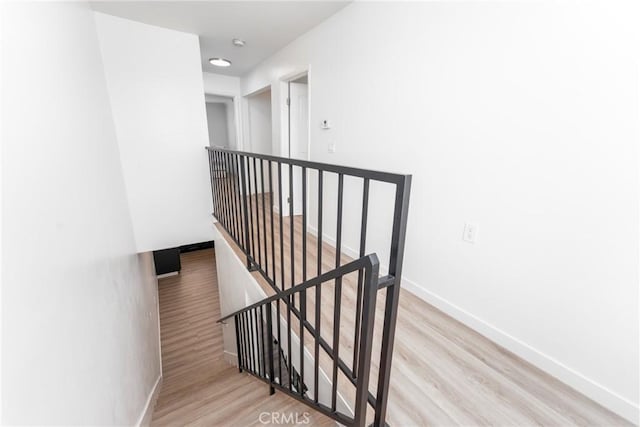 stairs with baseboards and wood finished floors