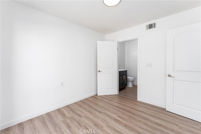 unfurnished bedroom featuring light wood-style floors, baseboards, and visible vents