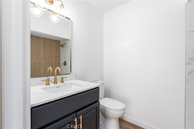 bathroom featuring vanity, toilet, and baseboards