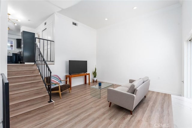 living area with recessed lighting, wood finished floors, visible vents, stairway, and crown molding