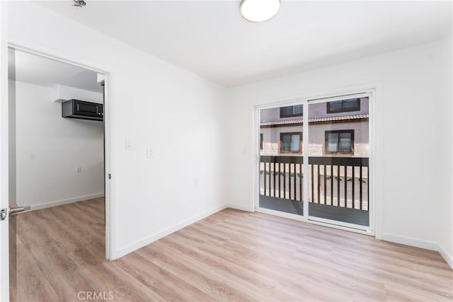 unfurnished room featuring light wood-style flooring and baseboards