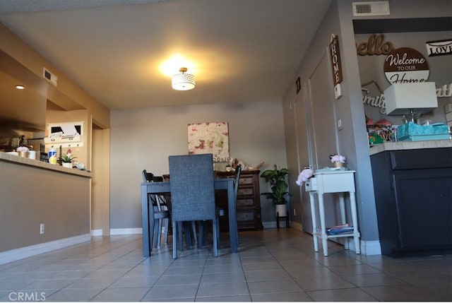 dining space featuring baseboards, visible vents, and tile patterned floors