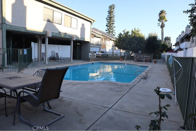 view of swimming pool featuring a patio area, fence, and a fenced in pool