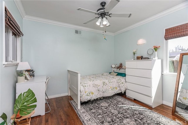 bedroom featuring ornamental molding, wood finished floors, visible vents, and baseboards