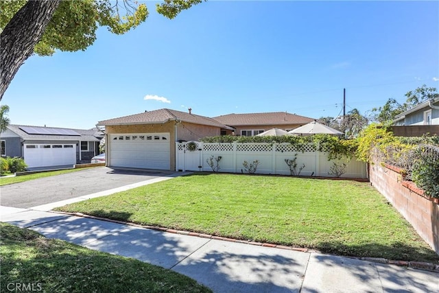 ranch-style home with aphalt driveway, an attached garage, fence, stucco siding, and a front lawn