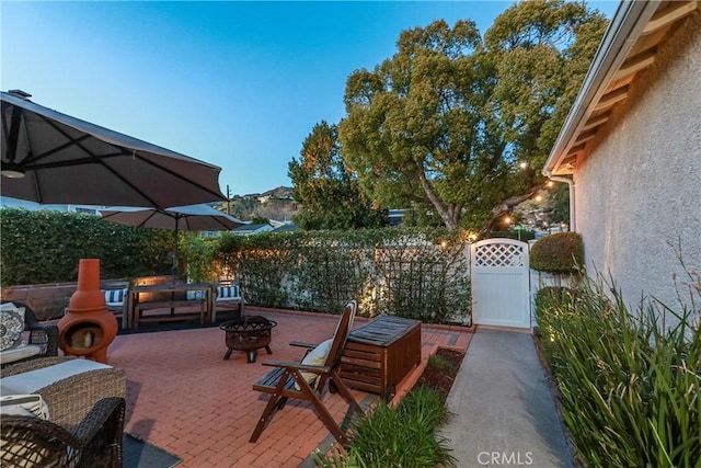 view of patio / terrace with a fire pit, a gate, and fence