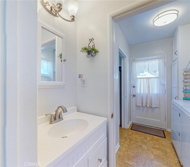 bathroom featuring a wealth of natural light, washer and dryer, and vanity