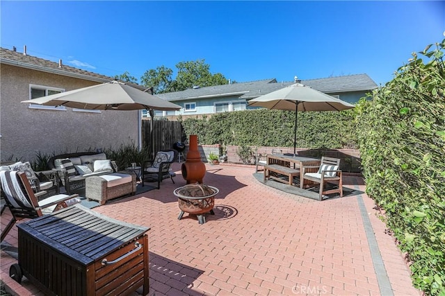 view of patio with fence and an outdoor living space with a fire pit