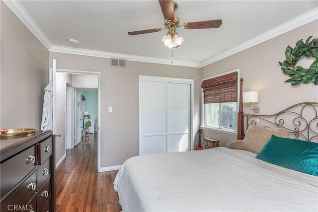 bedroom with baseboards, visible vents, ornamental molding, dark wood-style flooring, and a closet