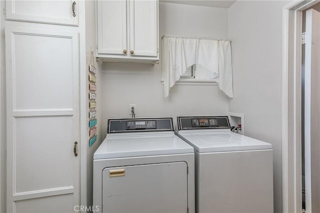 washroom featuring washing machine and dryer and cabinet space