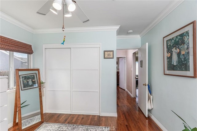 interior space with baseboards, a closet, ornamental molding, and wood finished floors