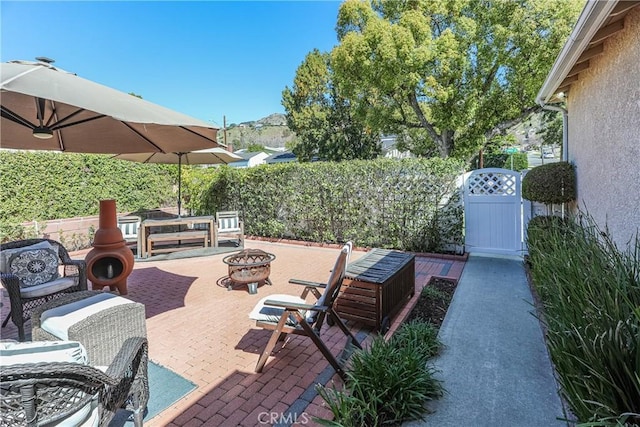 view of patio / terrace featuring fence and a fire pit