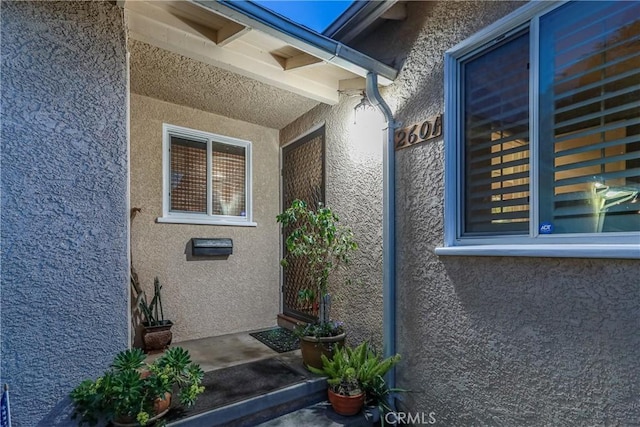 entrance to property featuring stucco siding