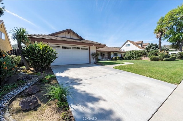 view of front facade featuring a front yard, concrete driveway, a garage, and stucco siding