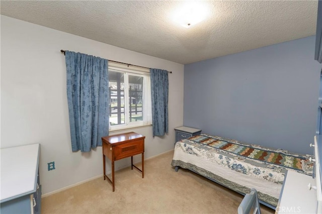 bedroom with baseboards, light colored carpet, and a textured ceiling