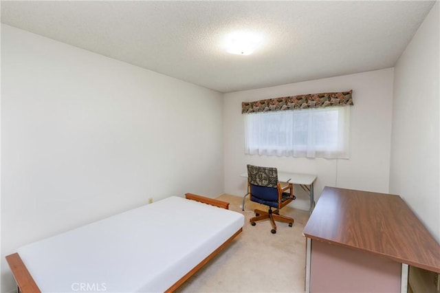 bedroom with light colored carpet and a textured ceiling