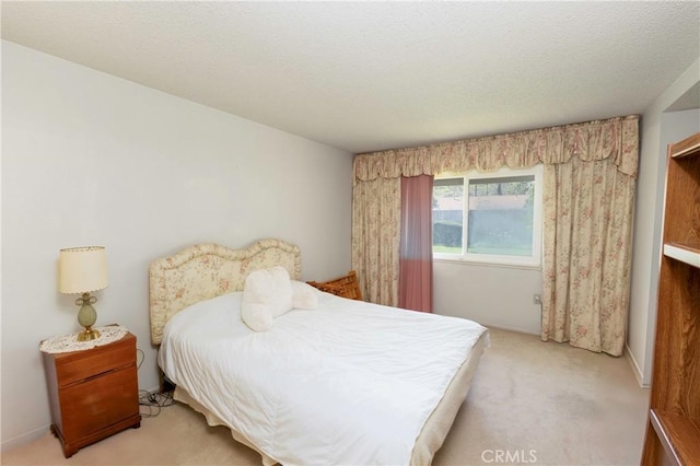 bedroom with baseboards, carpet floors, and a textured ceiling