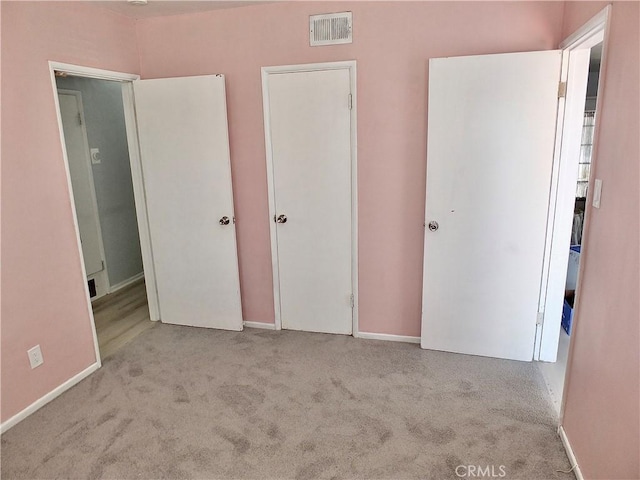 unfurnished bedroom with carpet floors, visible vents, and baseboards