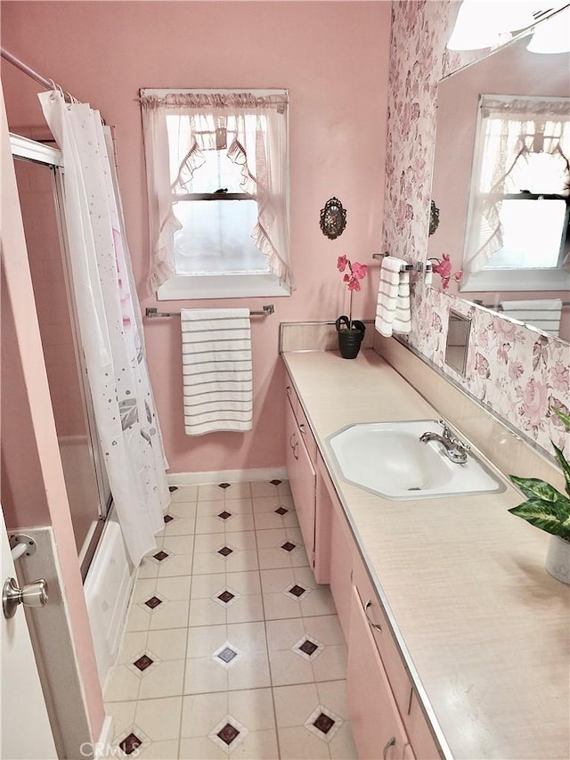 bathroom with shower / bath combo with shower curtain, vanity, baseboards, and tile patterned floors